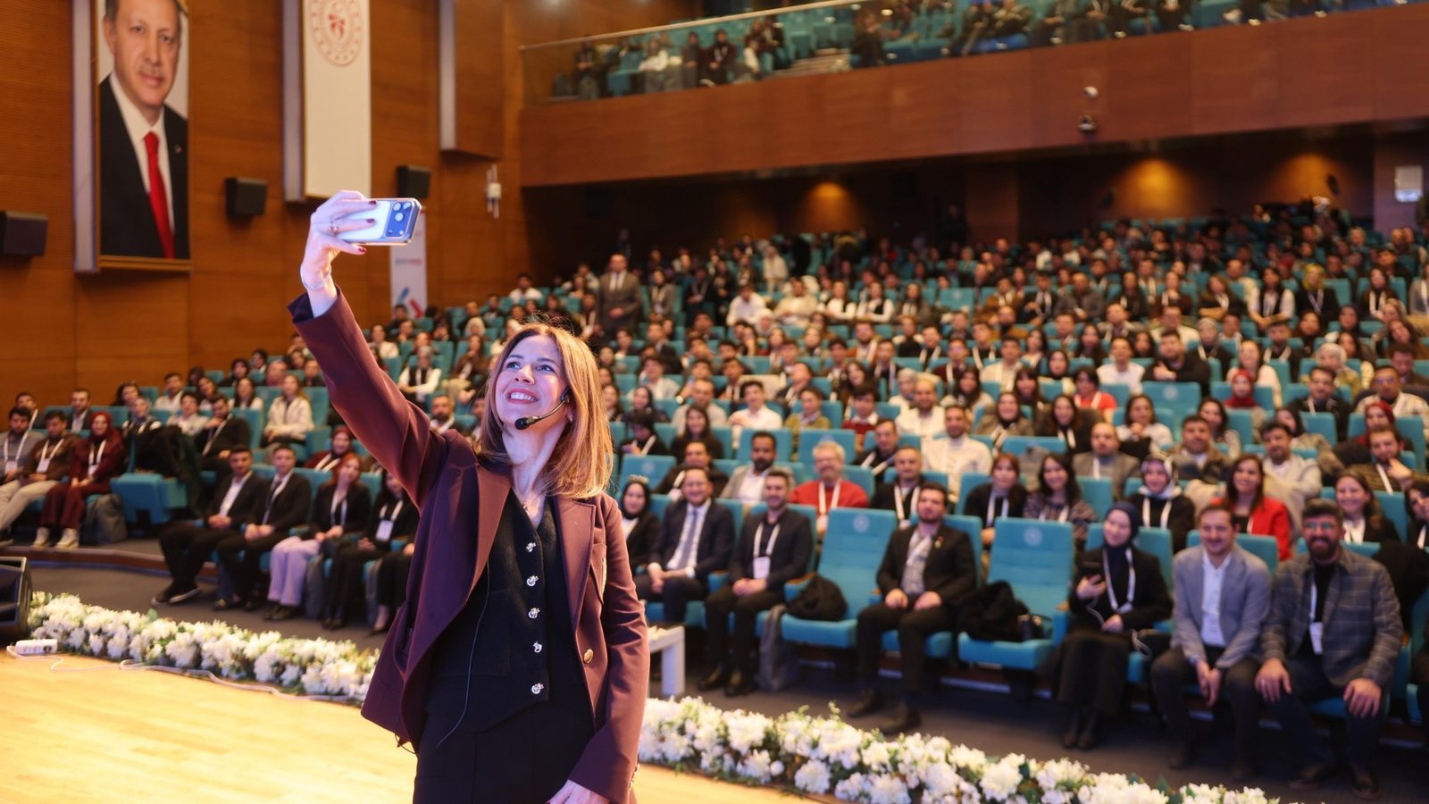 Defne İncekara, T.C. Gençlik ve Spor Bakanlığı GENÇ 2030 etkinliğinde sahneden salondaki katılımcılarla fotoğraf çekerken
